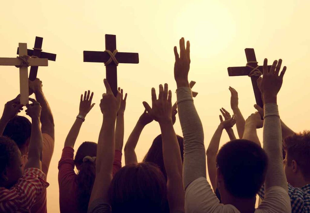A group of Christians hold up crosses.